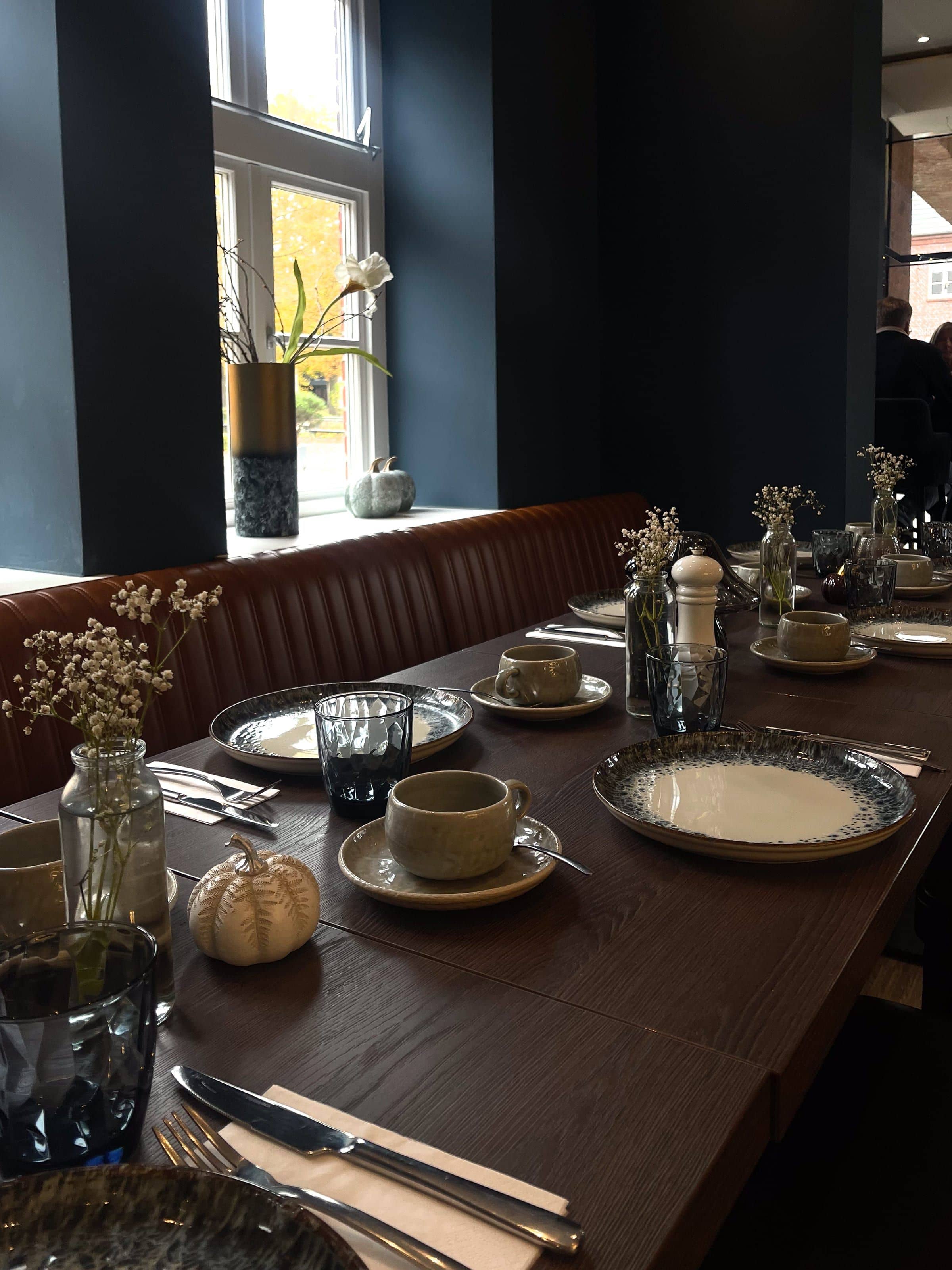 Festlich gedeckte lange Tafel am Sprossenfenster für eine Konfirmation