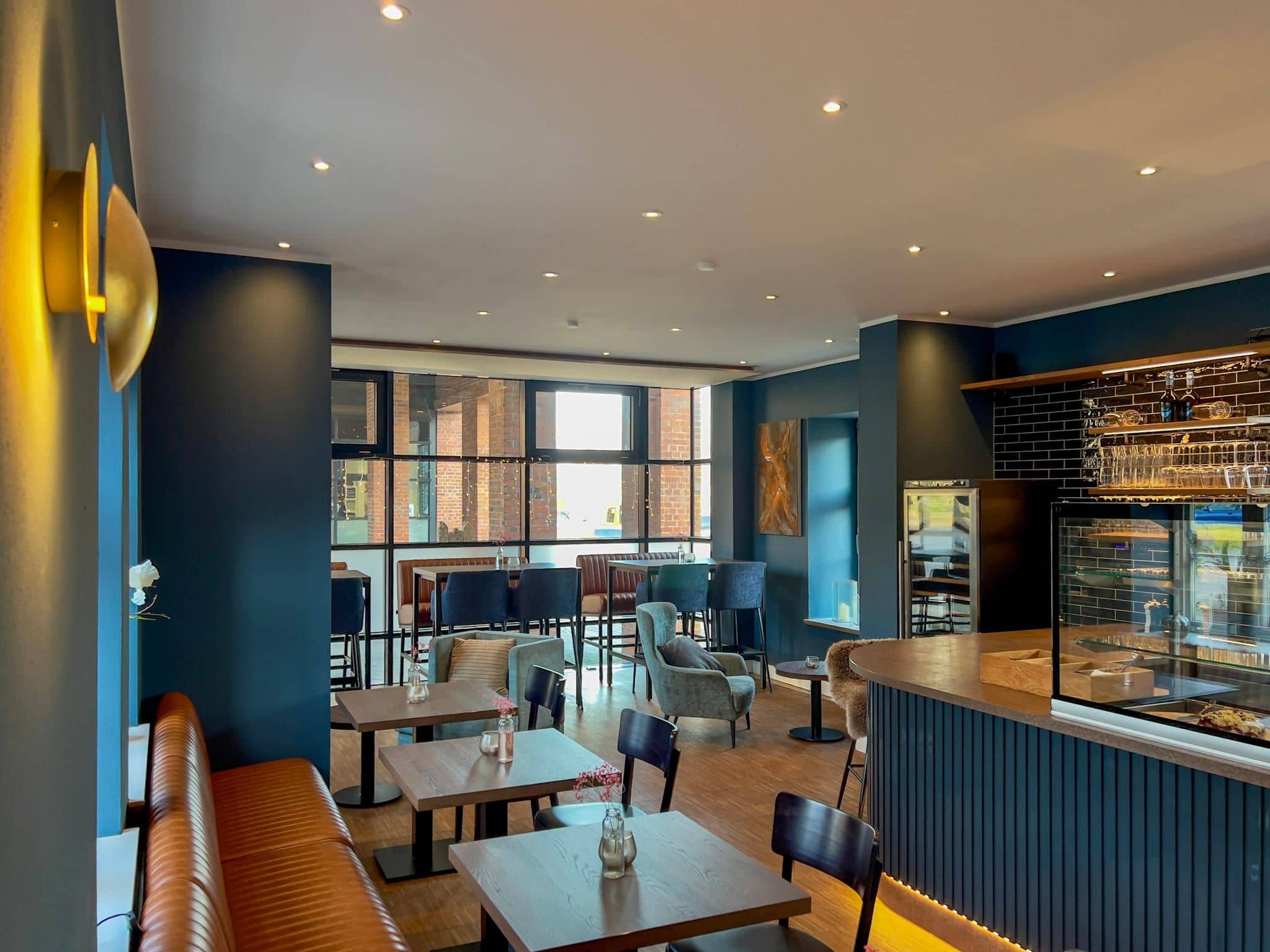 BLICKFANG Café-Innenraum mit Bar, Espressomaschine und blauen Wandfliesen, große Fensterfront zum Carlshöhe-Areal